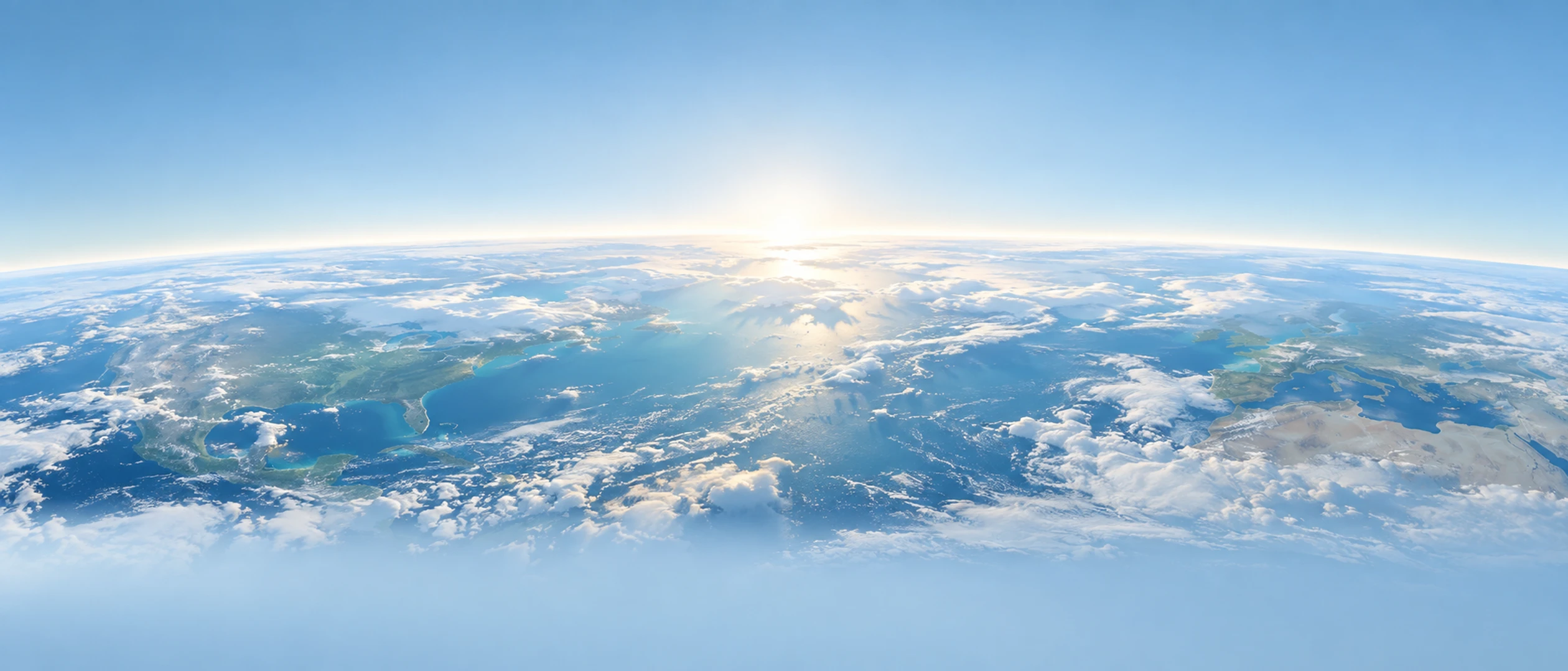 The curve of the Earth at dawn seen from the edge of the stratosphere, a bright blue atmosphere over sunlit clouds.
